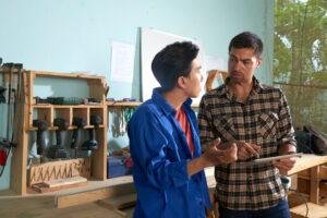 two colleagues coworking joiner workshop using tablet pc scaled